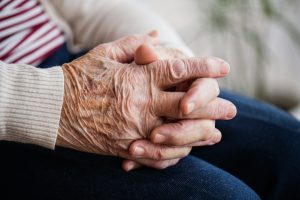 mains croisées d'une personne âgée en fin de vie